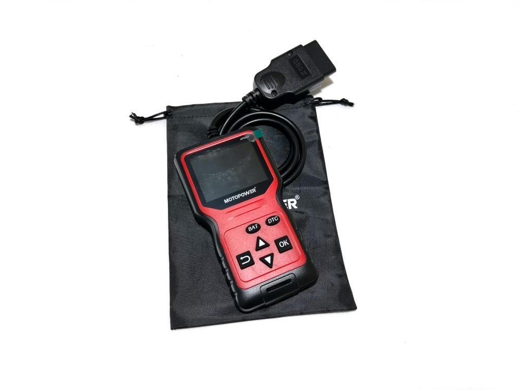 The OBD2 scanner from the kit, a red and black handheld unit with a screen, buttons and a cable ending in the OBD2 plug, resting on its black storage pouch