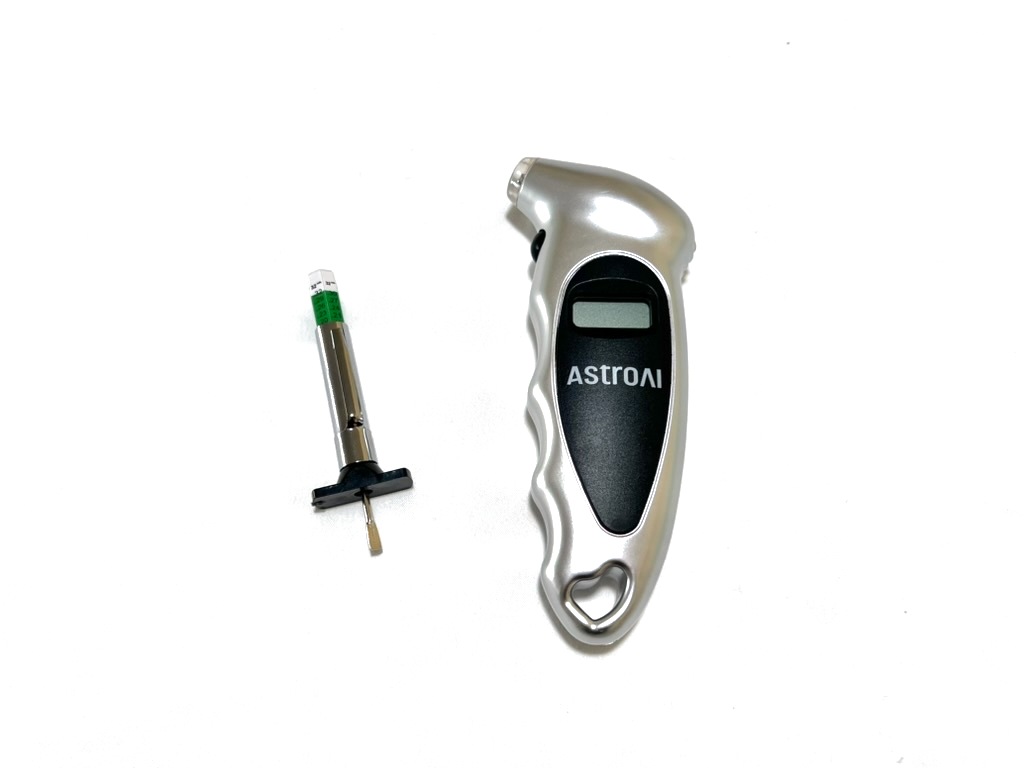 The silver digital tire pressure gauge and the small tread depth gauge from the kit side by side